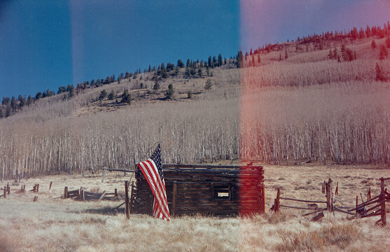 Remote Abandoned Cabin In The Colorado Mountains With A Flag Outside
