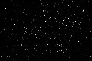 Flying silver sparkles, abstract luminous particles, white stardust isolated on a dark background.