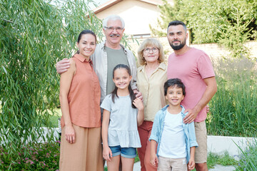 Horizontal medium long portrait if big family consisting of grandparents, parents and two children