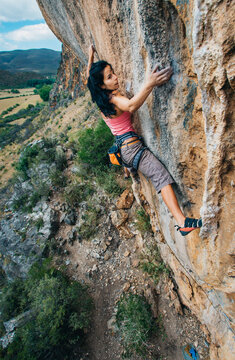 Female rock climber on a technical cliff in a mountain