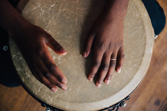 Young black girl's hands playing a djembe drum