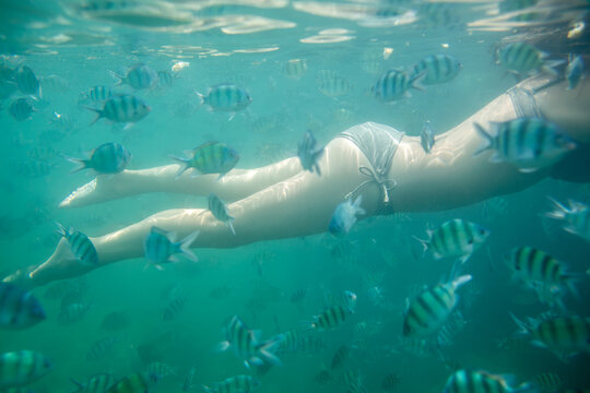 Young woman swimming in dark blue ocean water