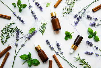 Bottles of essential oils with herbs and flowers