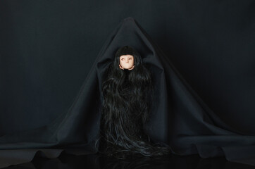 Scary black color ghost costume carry female doll head. Halloween concept.