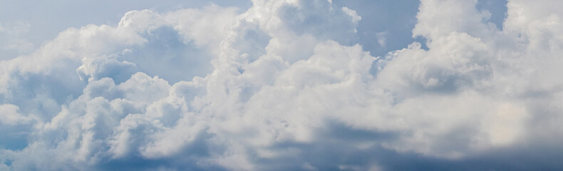 Panorama of the sky with picturesque white clouds in pastel colors