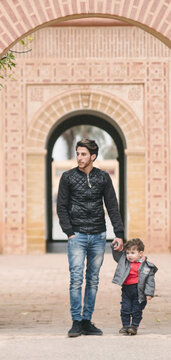 Arabic child holding hand of his older brother