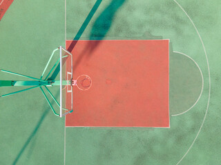 Drone aerial view of the basketball field half court basketball stands hoop. Green basketball court and hoop in the sunny day. Quite no people view of sports calm city lift concept Shanghai China