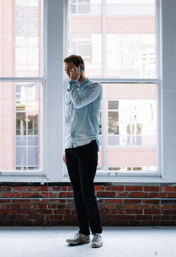 Young male working in studio space using technology