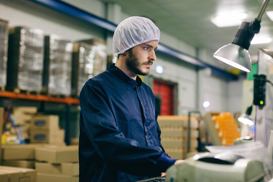 Man working with a computer in a factory.