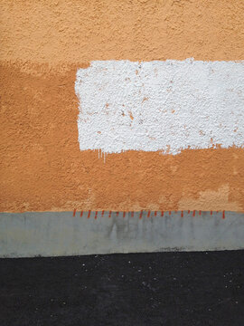 orange and white paint on a stucco wall