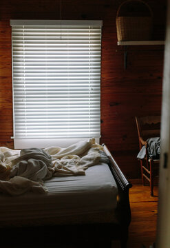 Messy bed sheets in room of house after nap by window