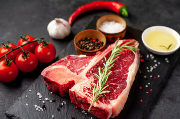 Fototapeta na wymiar raw t-bone steak with ingredients on stone background