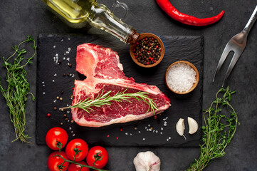 raw t-bone steak with ingredients  on stone background