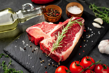 raw t-bone steak with ingredients  on stone background