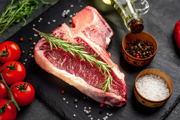 raw t-bone steak with ingredients  on stone background