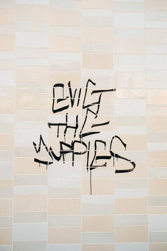 Evict the Yuppies"" drawn on the side of a building.