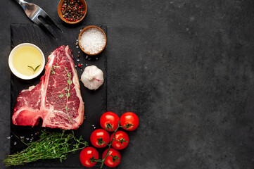 Obraz na płótnie Canvas raw t-bone steak with ingredients on stone background with copy space for your text