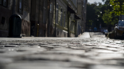 Old city paving stones with depressions between the stones, close-up, selective focus, dark tone.