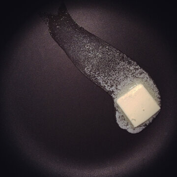 A pat of butter melting in a hat pan