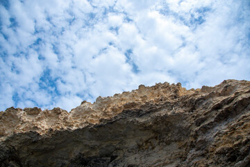 Textured rock against a cloudy blue sky. Natural background.