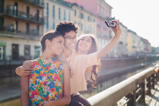 Three female friends taking a selfie in the city