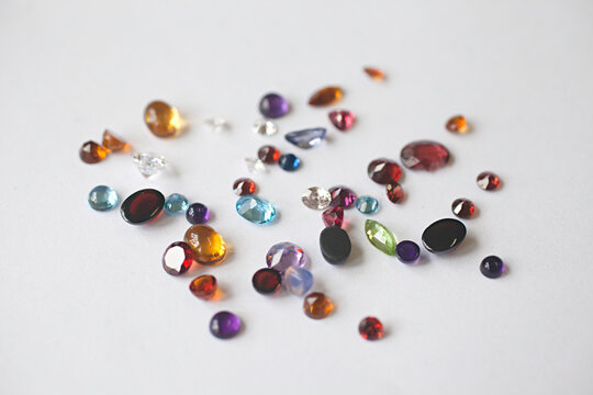 close up of colourful beads and gemstones on a white background