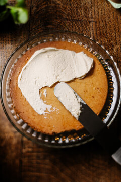 Spreading cream on a sponge cake.