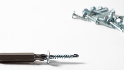 Self-cutters and screwdriver on a white background with space for text. Screw with thread - fasteners for construction, tools and accessories repair