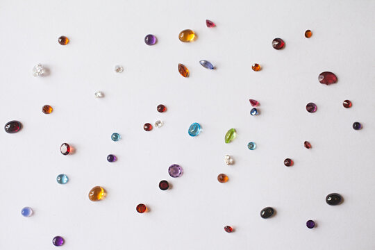 close up of colourful beads and gemstones on a white background