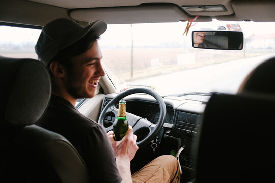 Drinking beer behind steering wheel of car