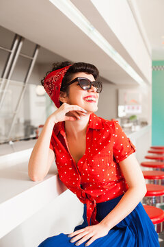 Portrait of beautiful rockabilly female in 50's stylish outfit smiling.
