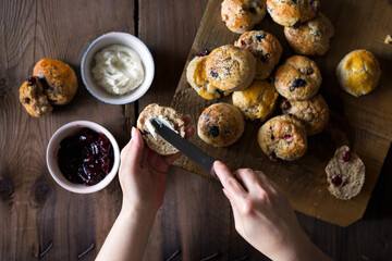 Putting goat cheese on cranberry scones