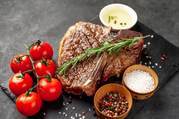 grill t-bone steak with ingredients on stone background
