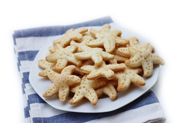 Salty cheese cookies in shape of a starfish on a plate  isolated on white background