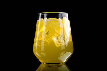  refreshing lemonade with lemon slices and ice cubes on black background