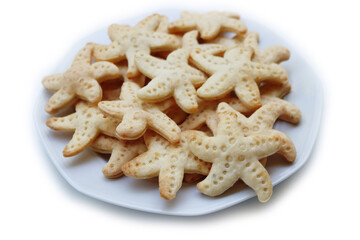 Salty cheese cookies in shape of a starfish on a plate  isolated on white background