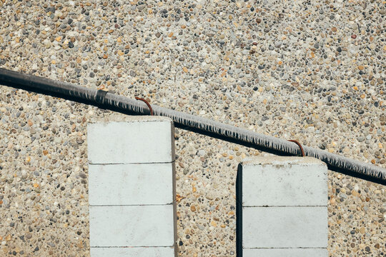 Stucco wall with gutter piping supported by cinder blocks