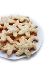 Salty cheese cookies in shape of a starfish on a plate  isolated on white background
