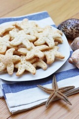 Salty cheese cookies in shape of a starfish on a plate on wooden table
