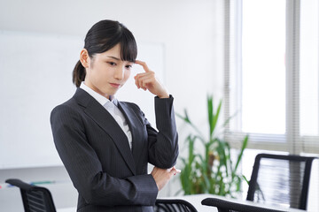 オフィスで考え事をする日本人女性ビジネスウーマン