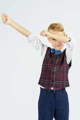 A portrait of a schoolboy who raised his hands up and makes a gesture with his hands. Isolated background.