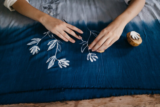 Female Artist Painting Flower Pattern on a Blue Fabric