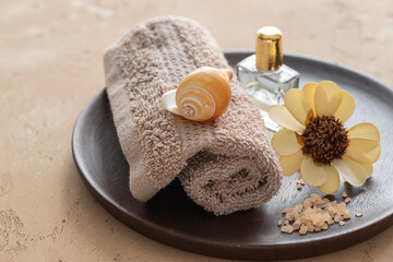 Obraz na płótnie Canvas Spa treatment and relax concept. Essential oil bottle, sea salt and towel on wooden try.