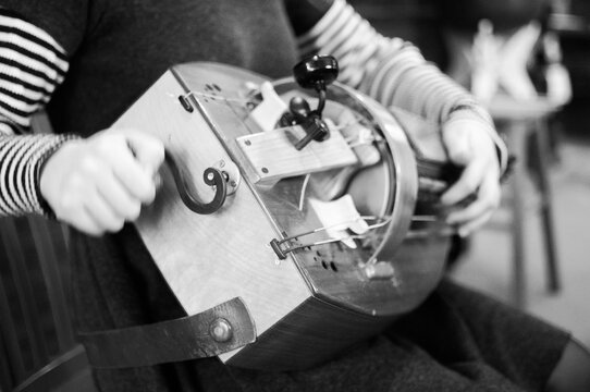 musician cranking a hurdy-gurdy
