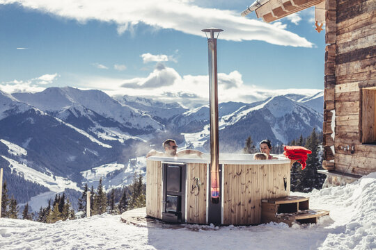 young family in outdoor jacuzzi in snowcovered alpine landscape
