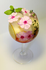 Chilled fruit tea with ice cubes and garnished with a sprig of mint