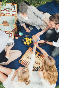 Spring Picnic - Overhead of Five Friends on Blue Quilt Sharing Food and Drink