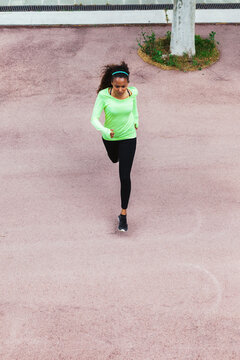 Overhead Of A Young Woman Running On The Street From Far Away.