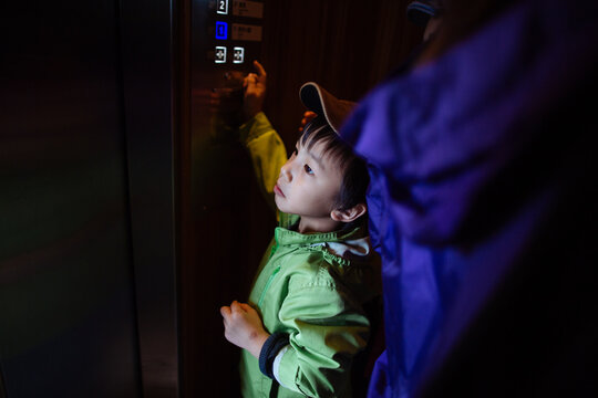 A cute and adorable kid volunteering to be an elevator operator