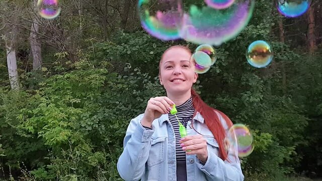 young woman blowing bubbles in the Park on a summer evening.